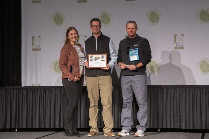 Milestone team members accept Indiana Parks and Recreation Association Corporate Partner of the Year Award on stage.